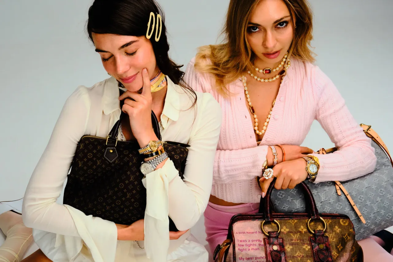 Two women seated with monogram, denim, and patchwork Louis Vuitton bags
